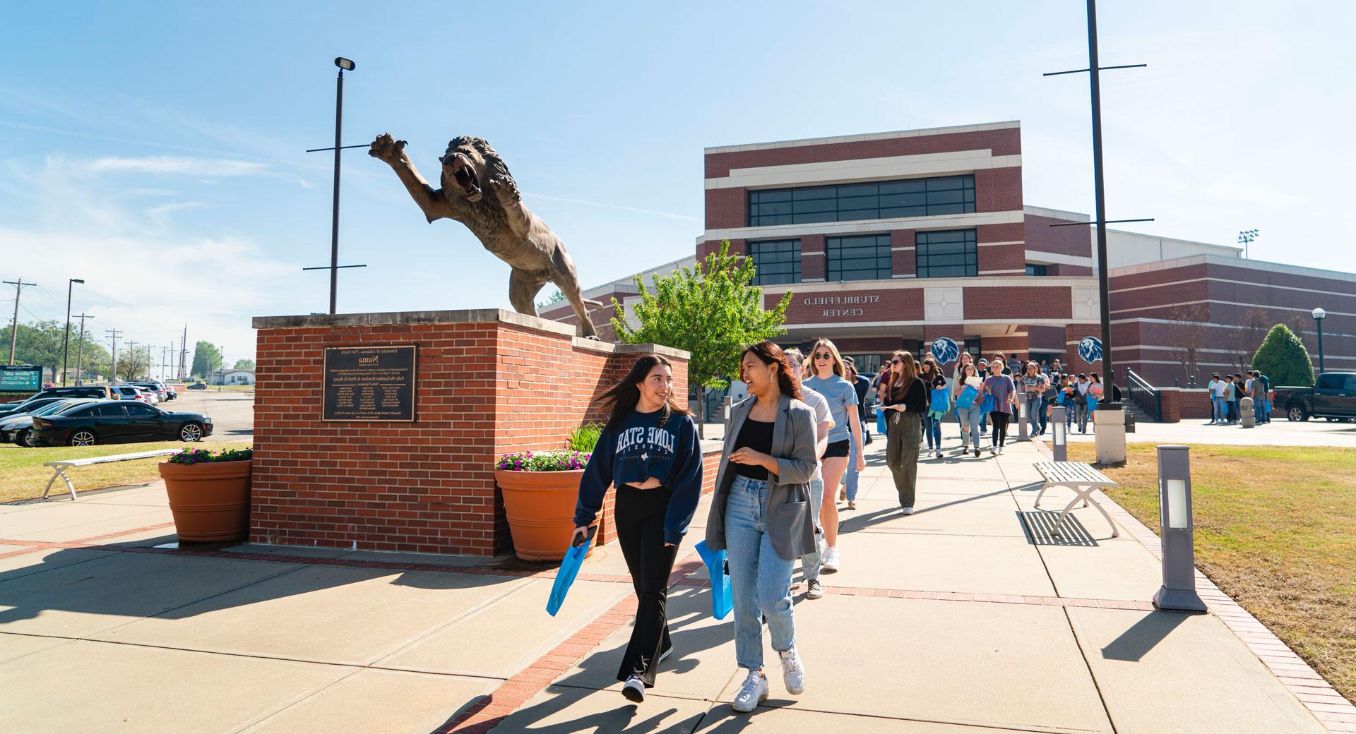 Students walk on the campus of UAFS at Den Day